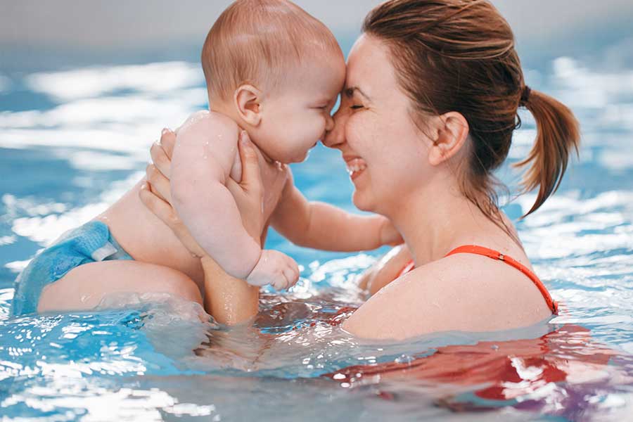 Mother holding baby in swimming pool