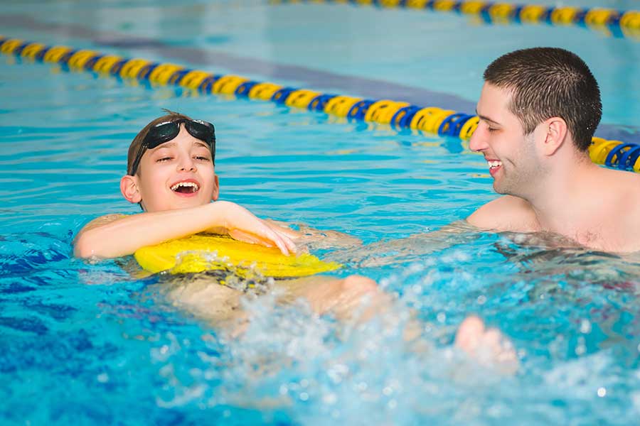 Boy learning to swim with float
