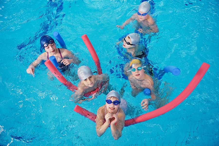 Children swimming class in swimming pool